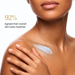 Close-up of a woman's neck, shoulder, and hand with a smear of light blue cream on her upper chest, against a white background with text reading '92% Agreed their overall skin looks healthier'.