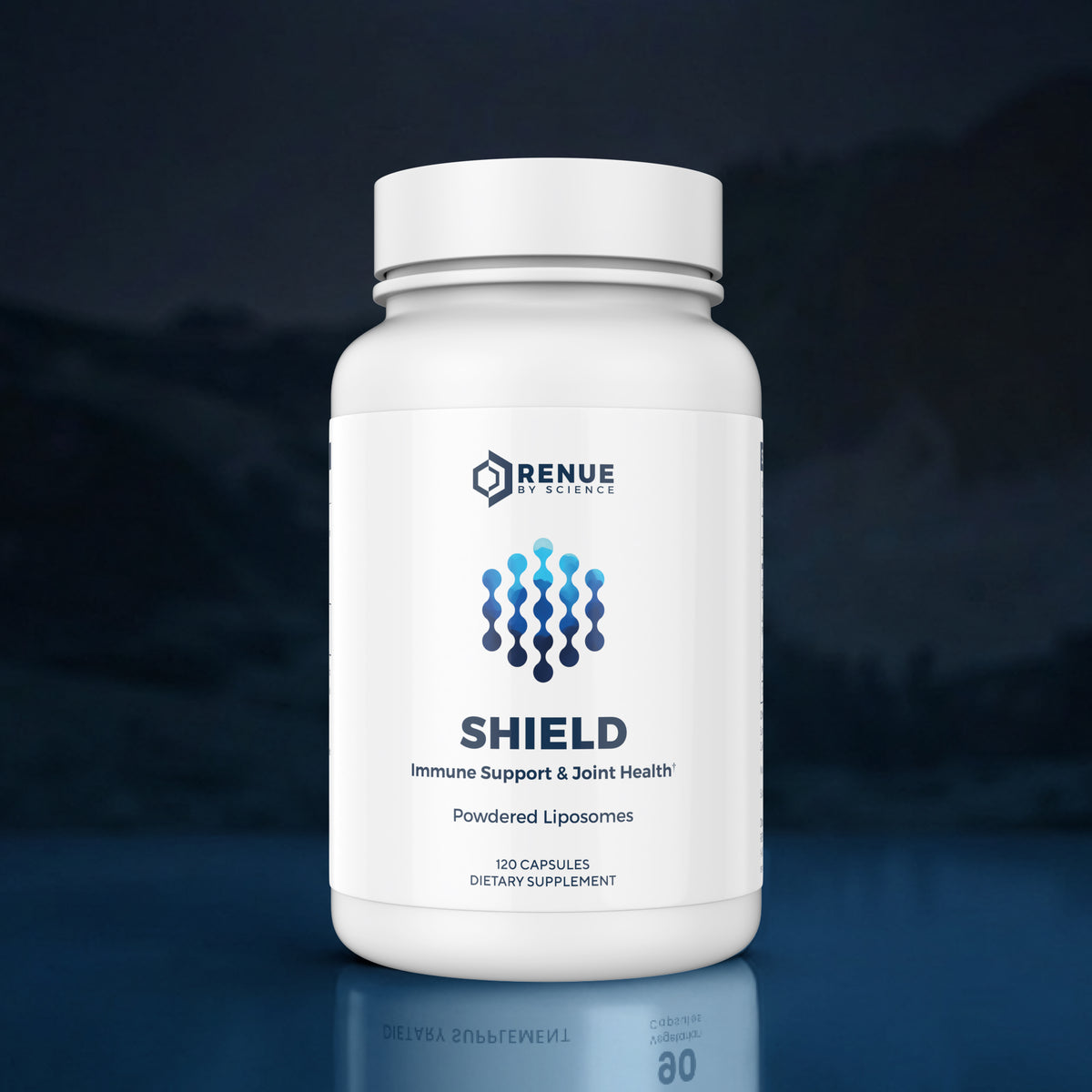 A white bottle of Renue Sciences Shield dietary supplement with a white cap, set against a dark blue, misty background with a subtle reflection on the surface below.
