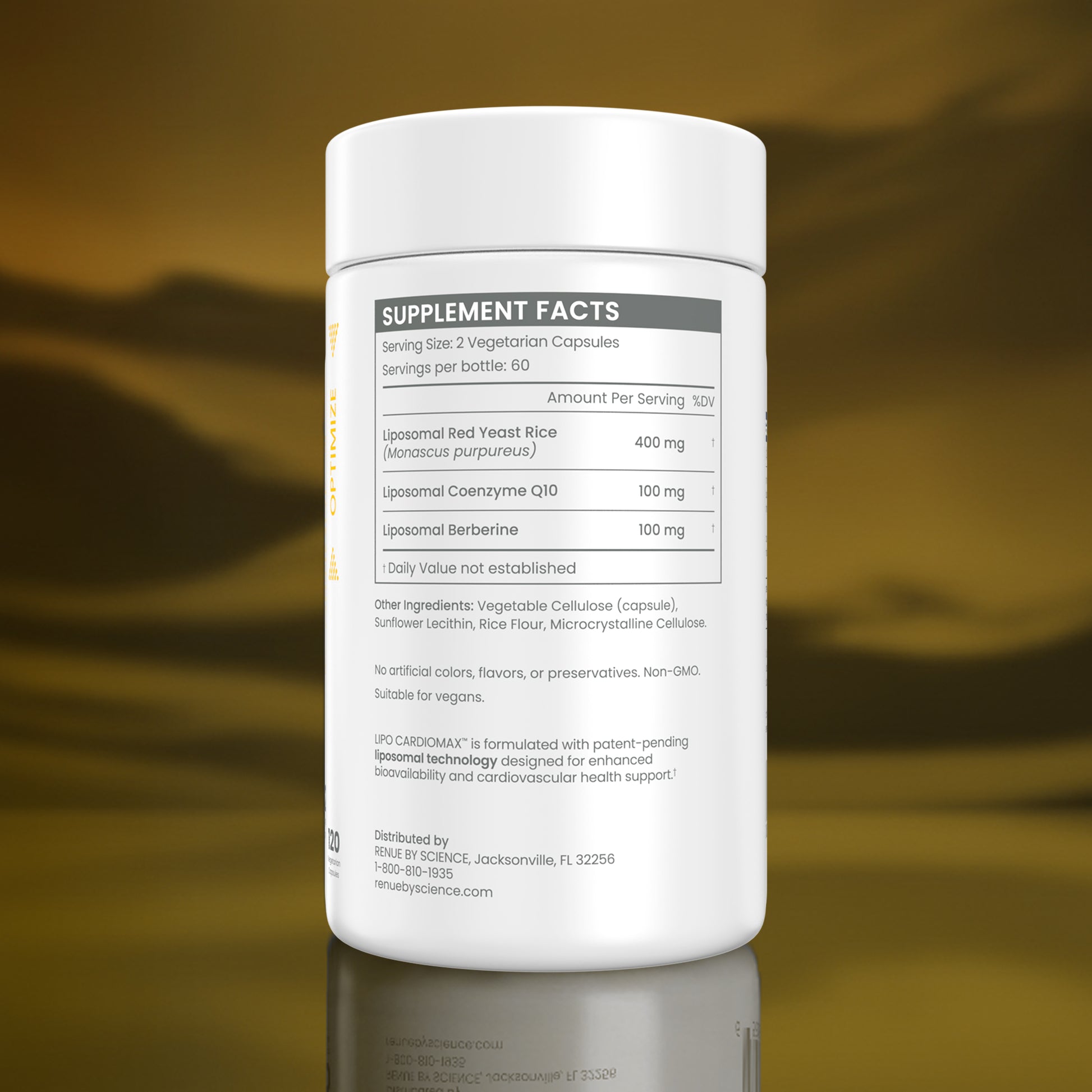 A white supplement bottle shown from the back, featuring a detailed 'Supplement Facts' label with text and a nutrition table. The bottle is set against a reflective, metallic gold background.