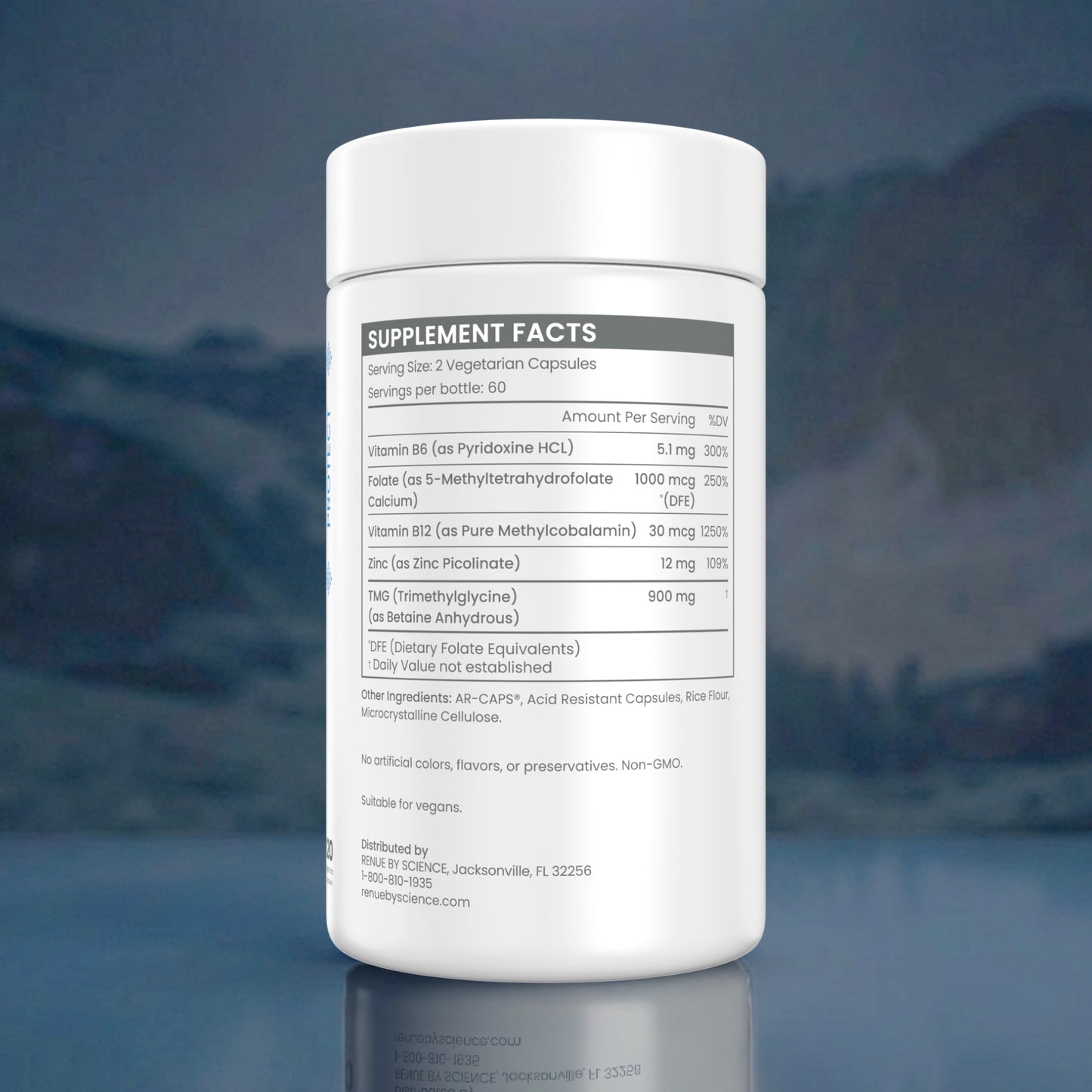 A white plastic bottle of dietary supplements shown from the back, displaying the supplement facts label against a dark, moody background with a faint mountain silhouette.