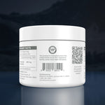 A white plastic supplement jar shown from the back, displaying the GMP seal, barcode, and QR code on a dark reflective background.