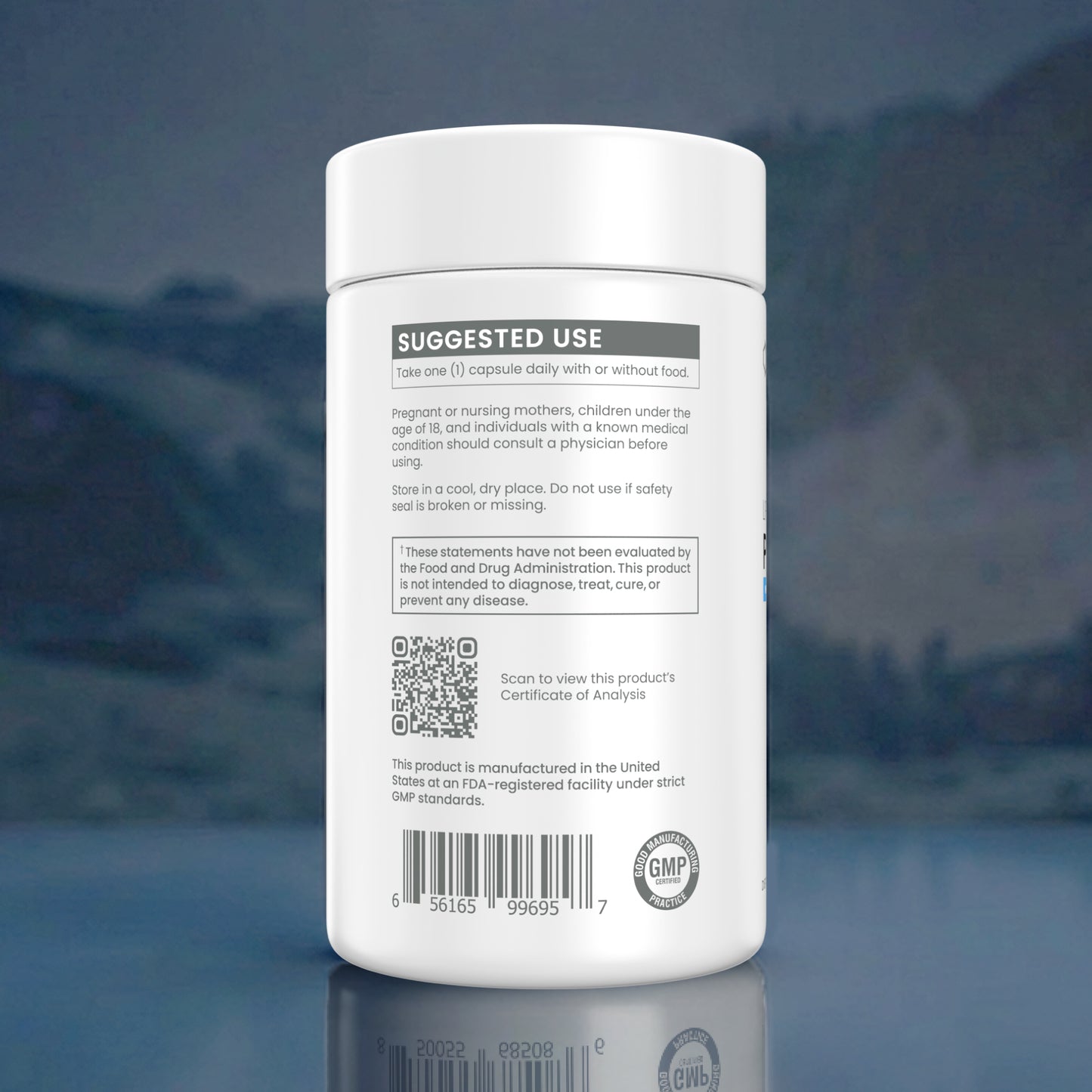 A white plastic supplement bottle shown from the back, featuring a white label with black text, a QR code, and a GMP seal, set against a dark blue reflective background.
