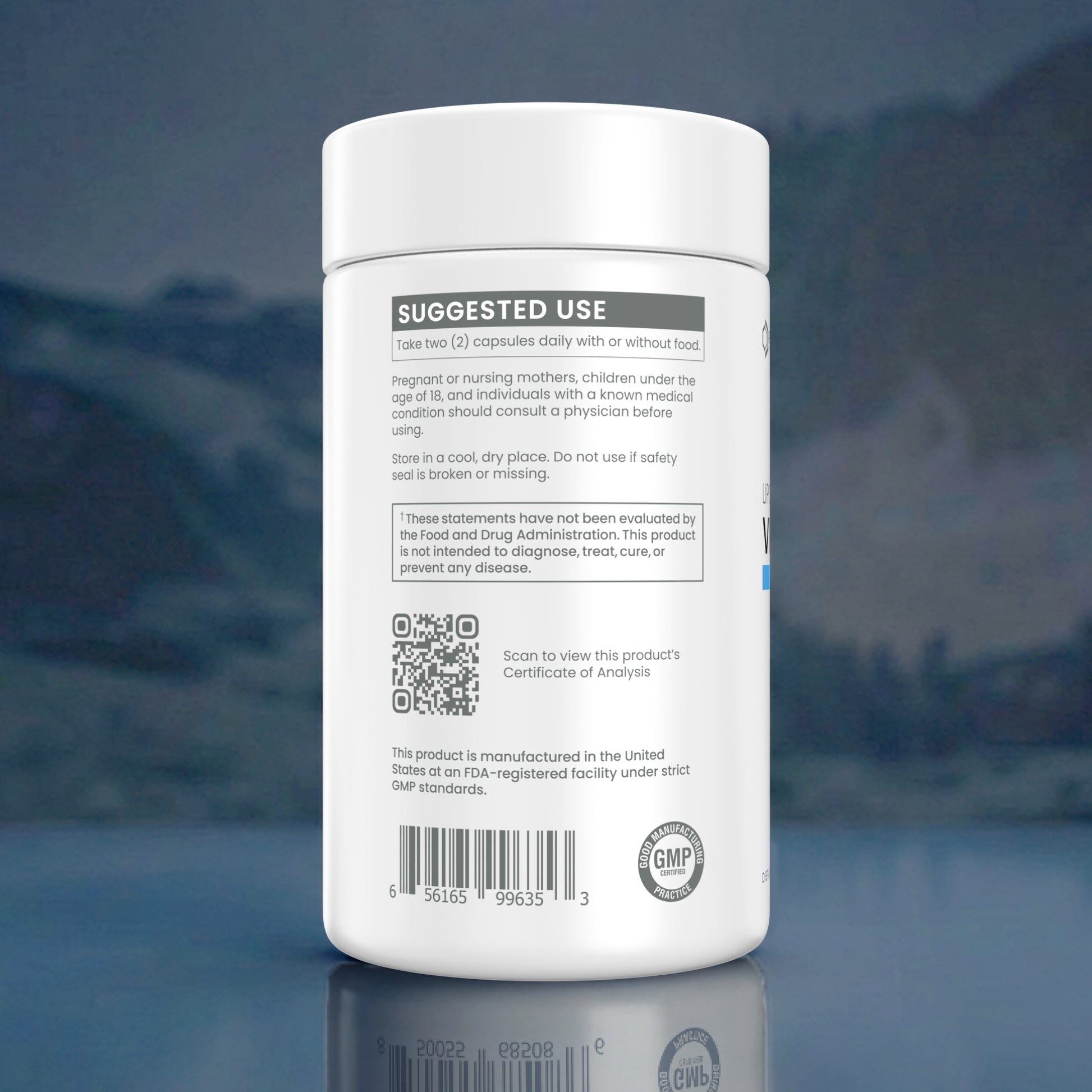 A white plastic bottle of dietary supplement capsules shown from the back, featuring a white label with black text, a QR code, and a GMP seal, set against a blurred blue-toned background.