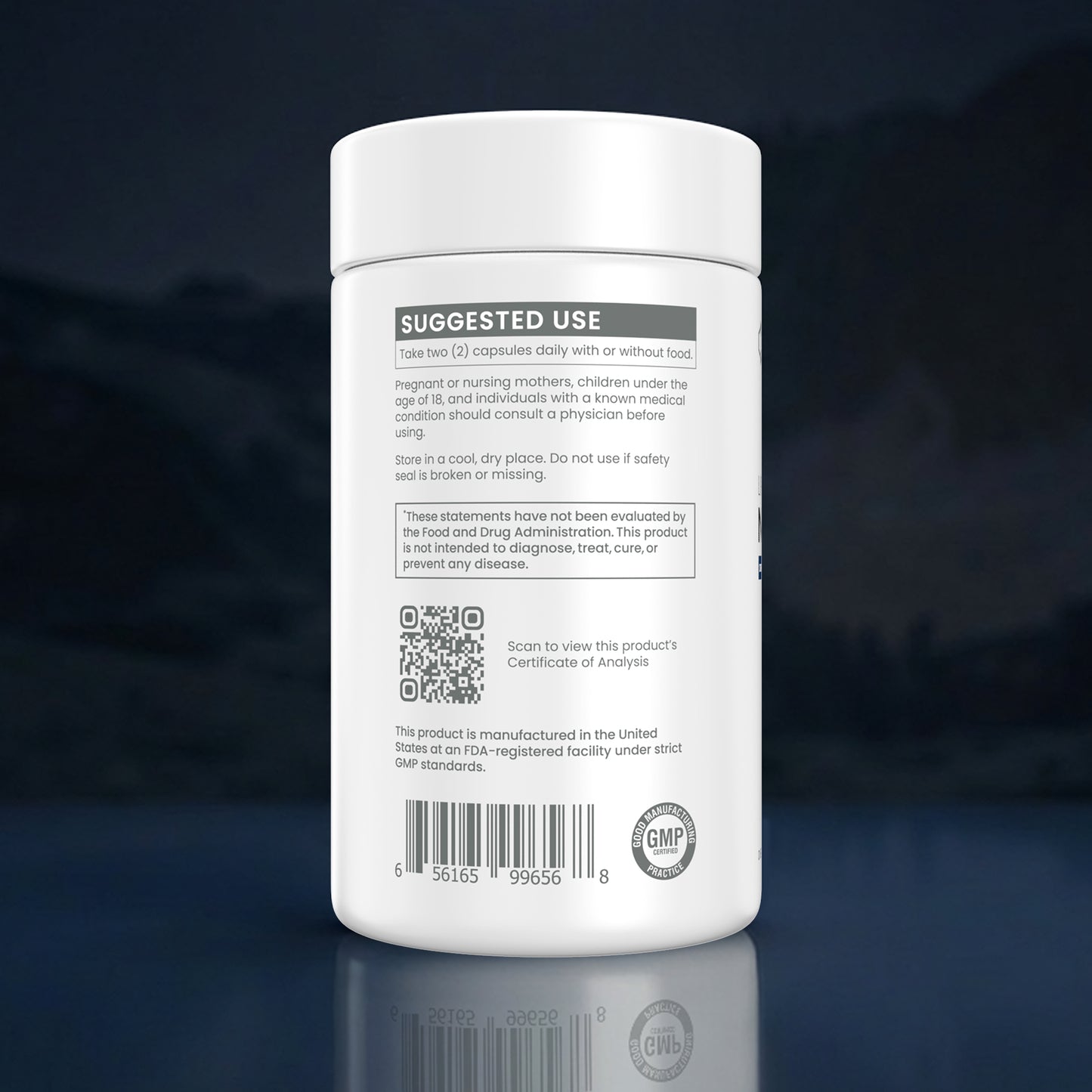A white plastic supplement bottle shown from the back, featuring a detailed black and gray label with 'SUGGESTED USE', a QR code, a barcode, and a 'GMP' seal, set against a dark blue gradient background with a reflection below.