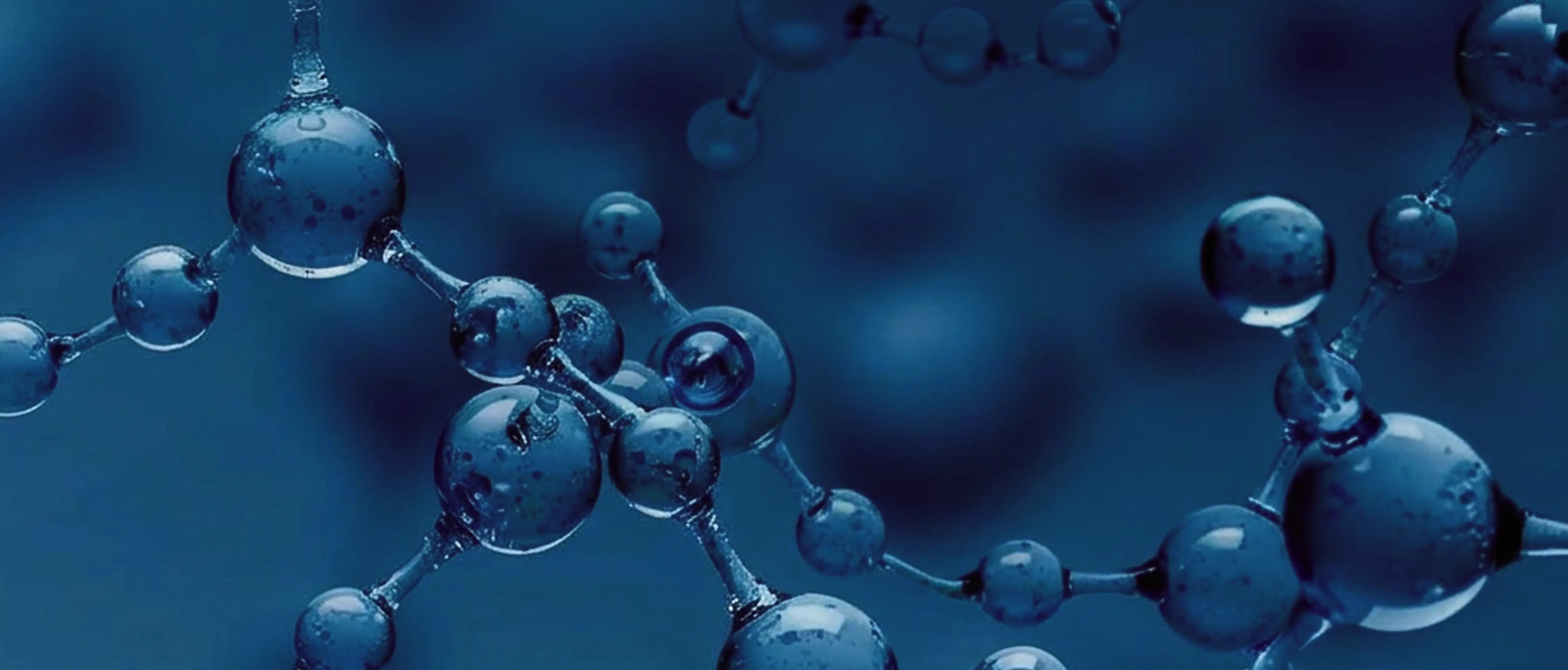 Molecular structure with blue spherical atoms on a dark blue background