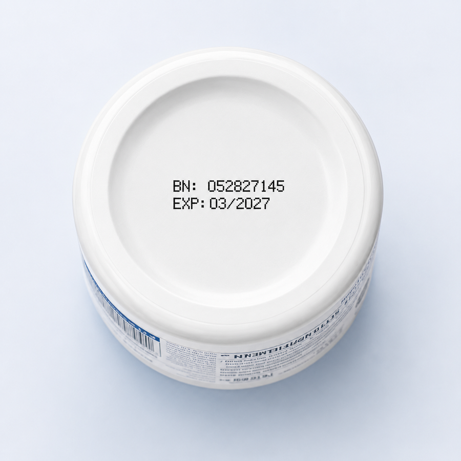 Top-down view of a white cosmetic jar lid showing printed black text with batch number and expiration date, on a light blue background.