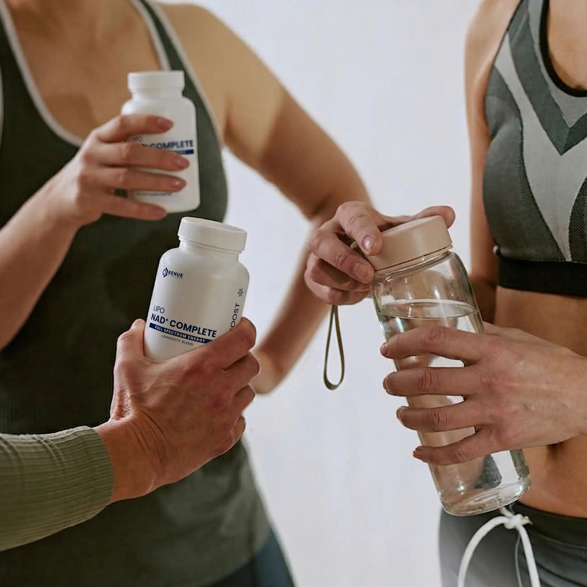 Three people holding bottle of supplement and bottle of water.