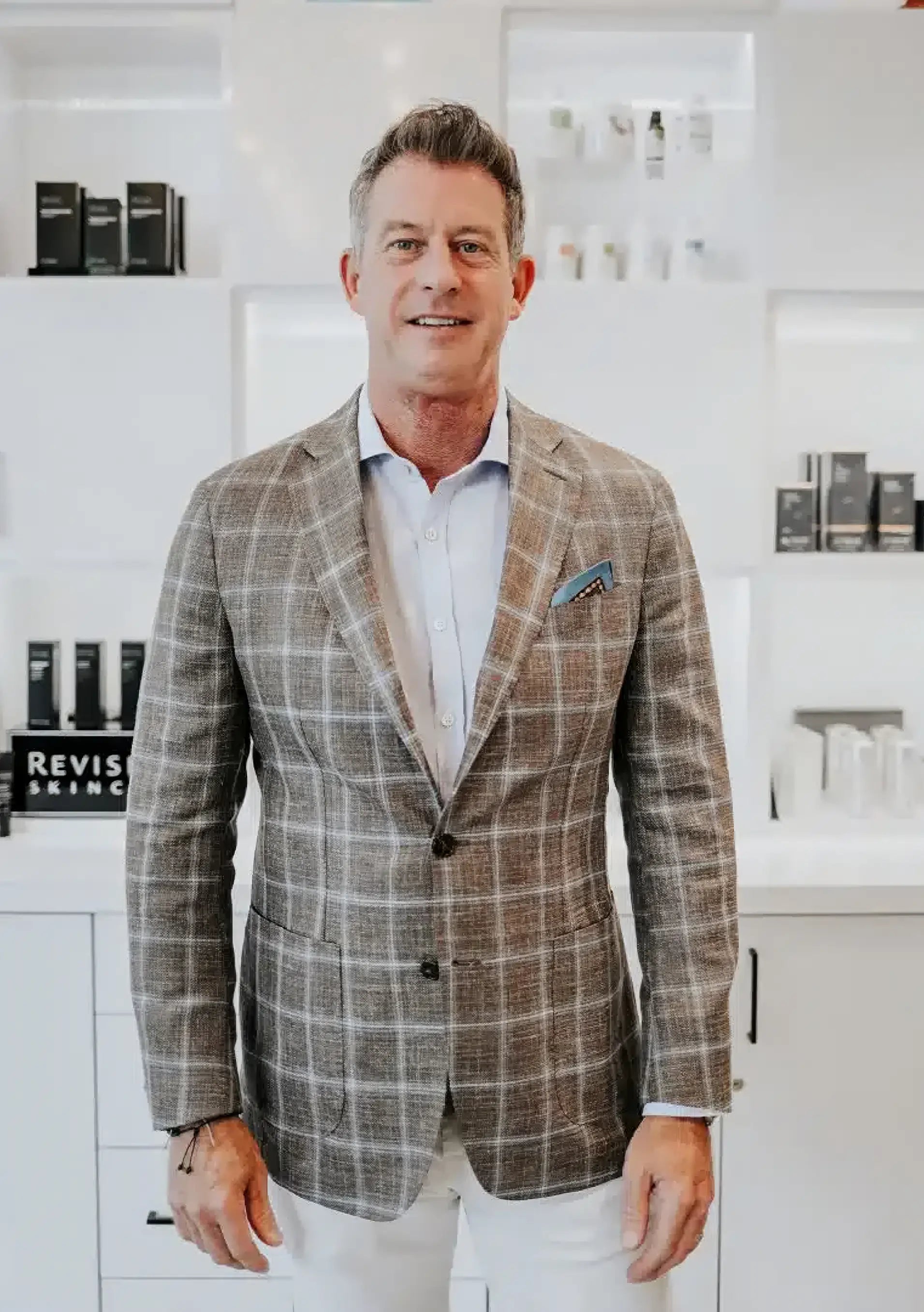 Man wearing a plaid blazer in a modern interior setting